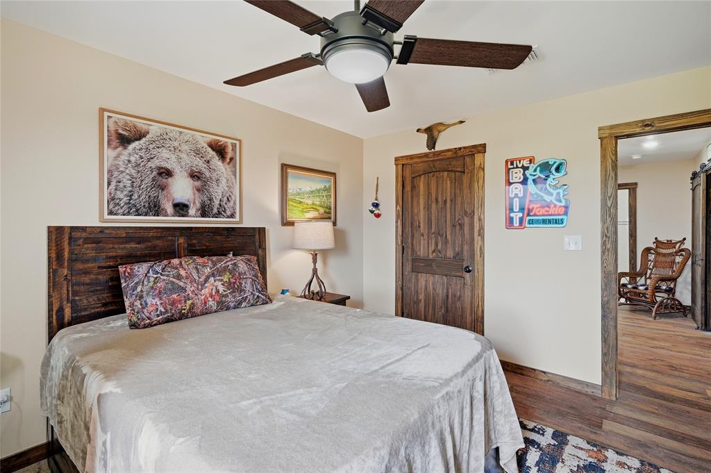 4652 Old Southmayd Road Sherman, TX 75092 - Photo 28 of 40 a bedroom with a large bed and a chandelier