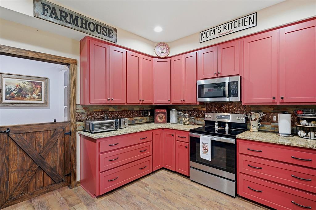 4652 Old Southmayd Road Sherman, TX 75092 - Photo 10 of 40 a kitchen with stainless steel appliances granite countertop a stove microwave and cabinets