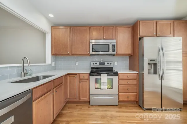 a kitchen with stainless steel appliances granite countertop a refrigerator stove a sink and dishwasher