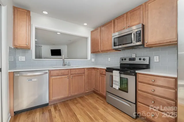 a kitchen with stainless steel appliances granite countertop a sink and a microwave