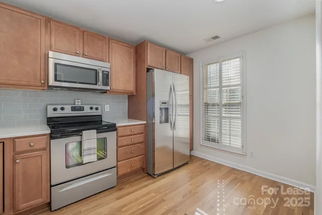 a kitchen with granite countertop a refrigerator stove and microwave
