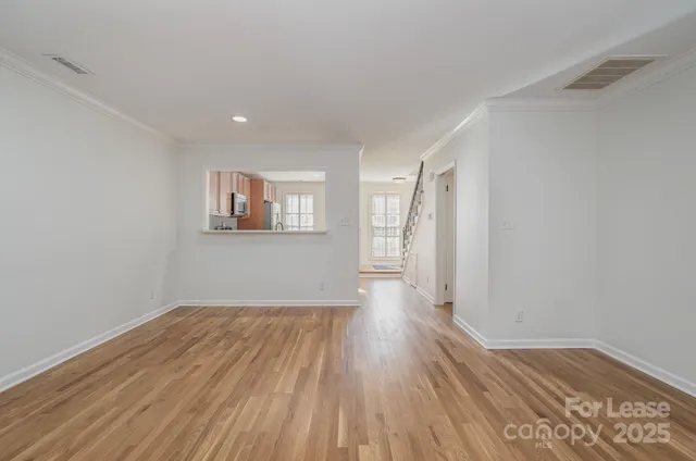 a view of a room with wooden floor and window