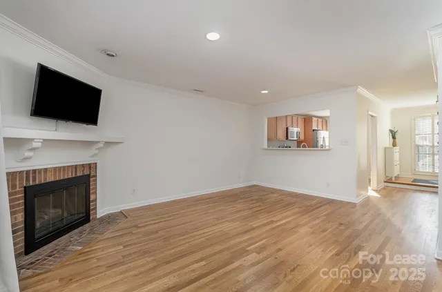 a view of empty room with wooden floor and fireplace