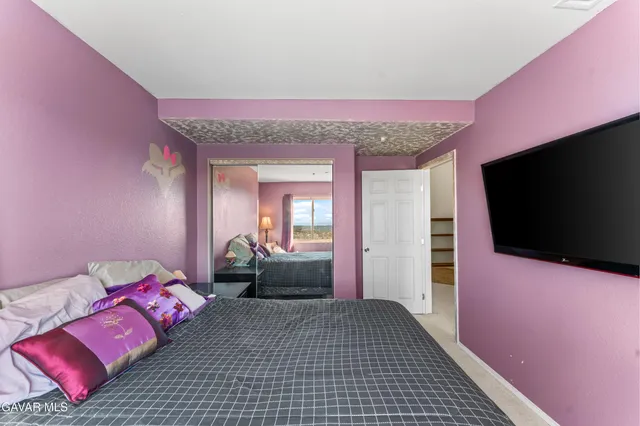 a bedroom with a bed and a flat screen tv