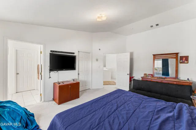 a bedroom with a bed and a flat screen tv