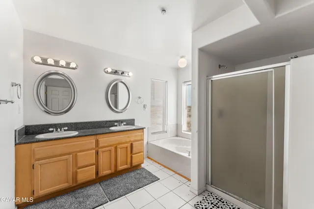 a room with round mirror and cabinets