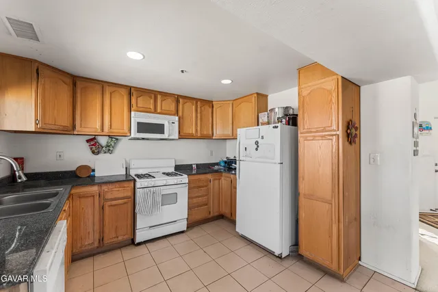 a kitchen with a refrigerator a stove top oven a sink and cabinets