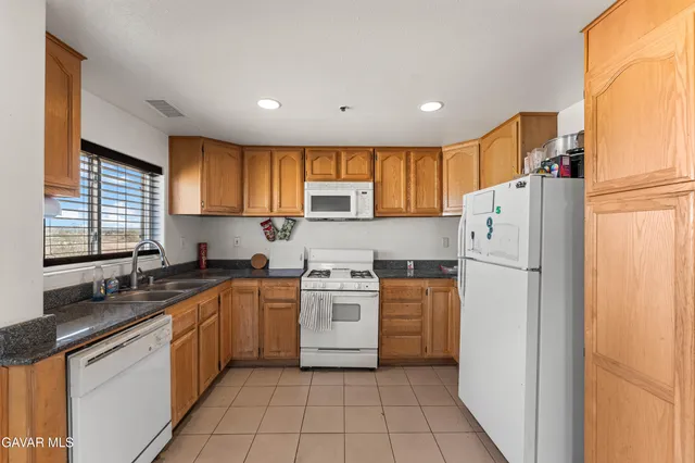 a kitchen with a refrigerator a sink and wooden cabinets