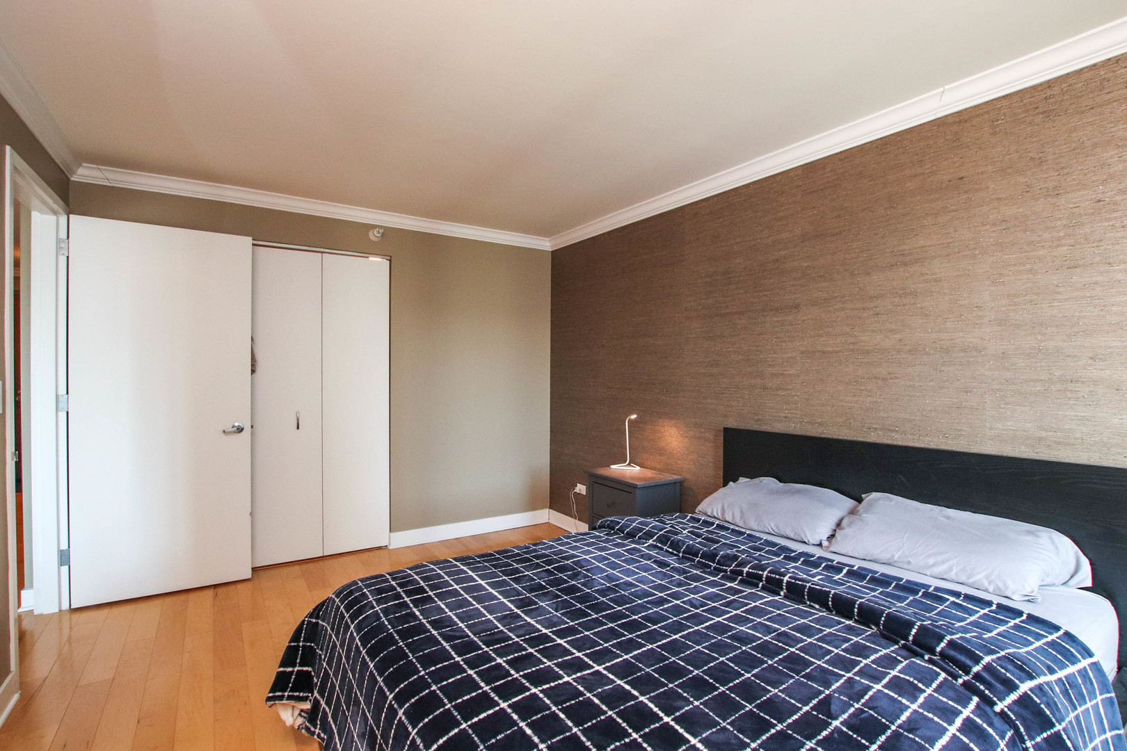 2 East Erie Street, Unit 2101 Chicago, IL 60611 - Photo 11 of 19 a bedroom with a bed and wooden floor