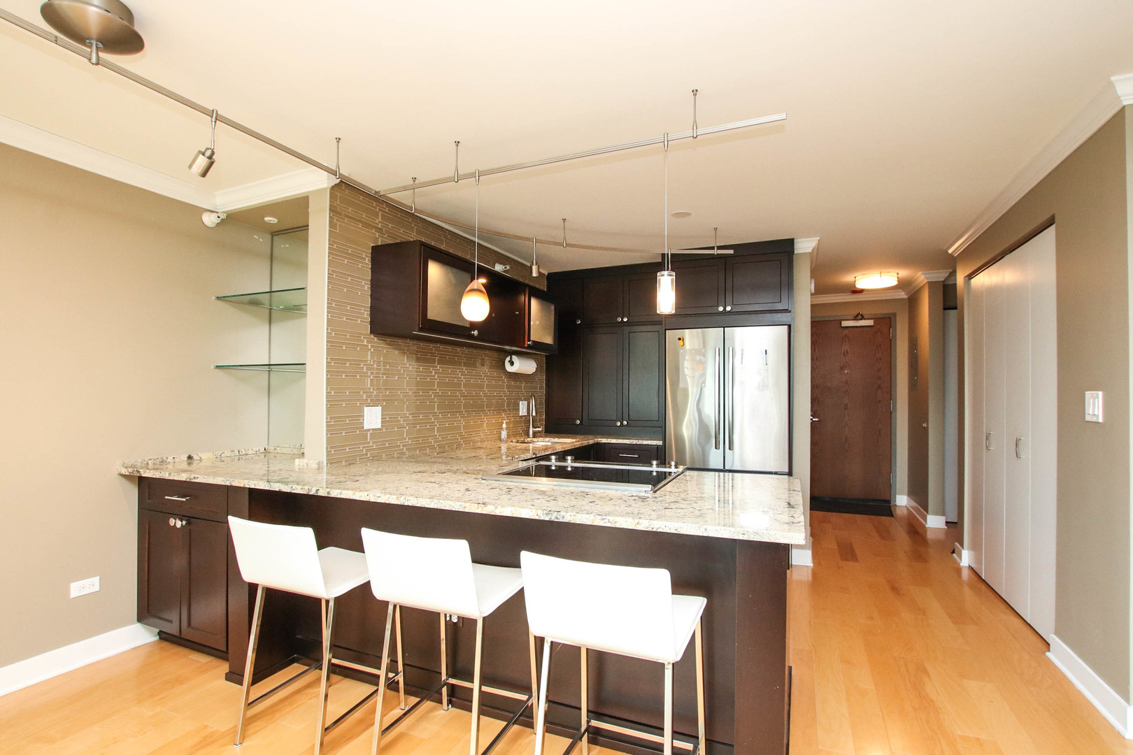 2 East Erie Street, Unit 2101 Chicago, IL 60611 - Photo 4 of 19 a kitchen with stainless steel appliances kitchen island granite countertop a table chairs in it and wooden floors
