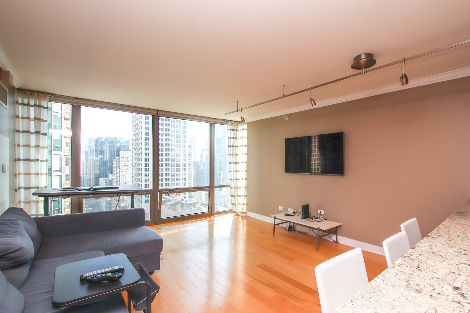2 East Erie Street, Unit 2101 Chicago, IL 60611 - Photo 7 of 19 a living room with furniture and a flat screen tv