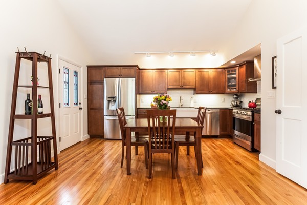 18 Mountain Road Waltham, MA 02451 - Photo 6 of 22 a kitchen with stainless steel appliances a dining table chairs stove refrigerator and cabinets