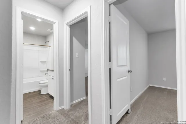 a bathroom with a granite countertop toilet and a glass door