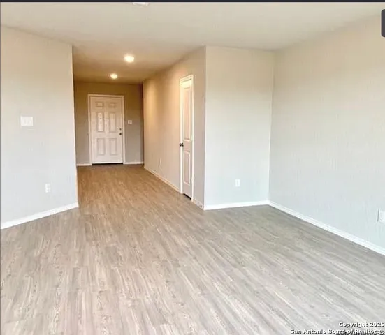 a view of an empty room and wooden floor