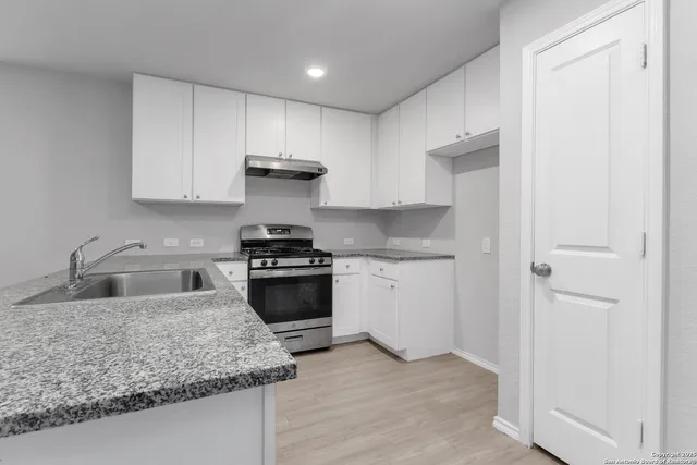 a kitchen with stainless steel appliances granite countertop a sink stove and refrigerator