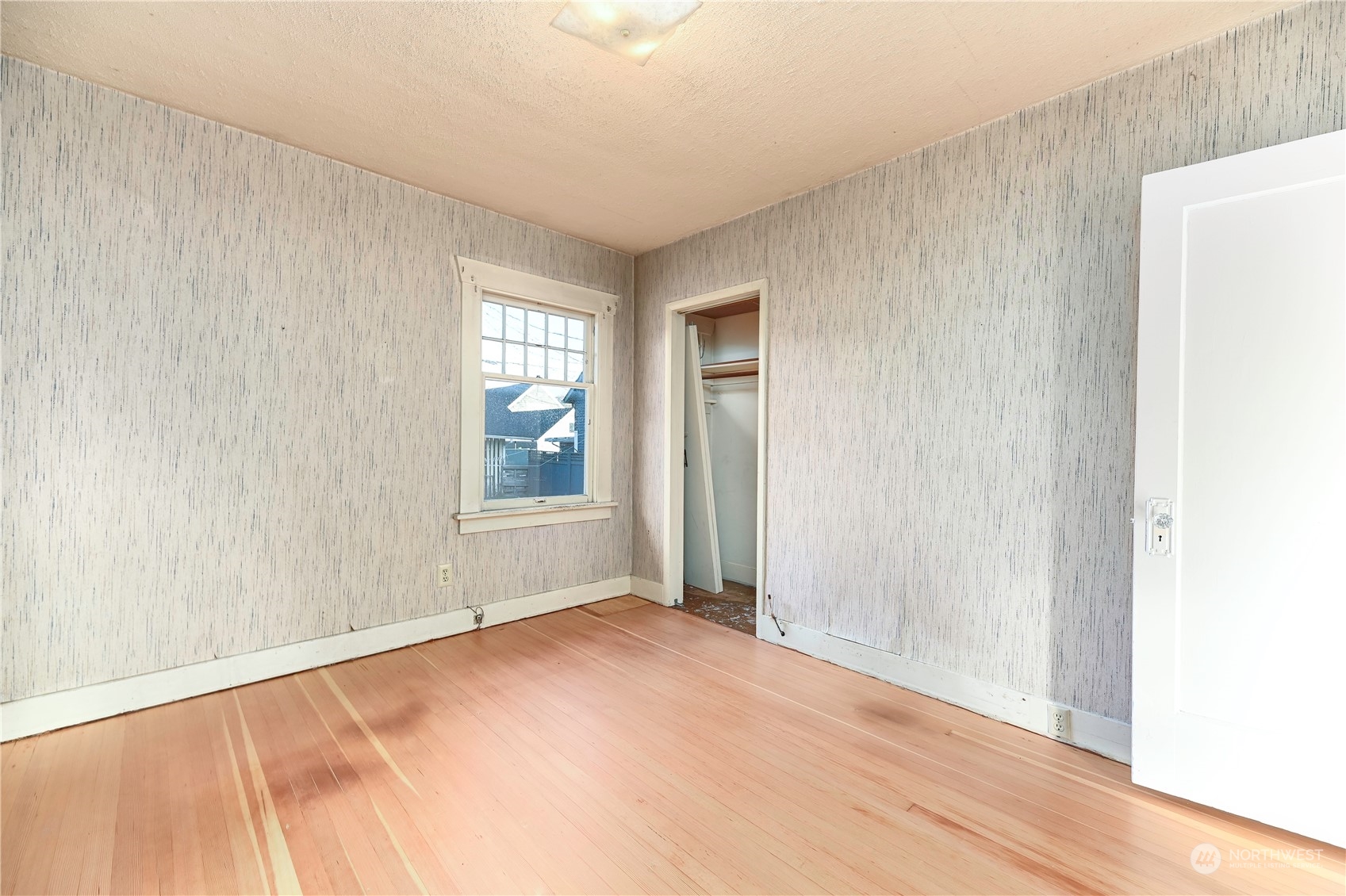 1419 Rucker Avenue Everett, WA 98201 - Photo 16 of 39 a view of an empty room with wooden floor and a window