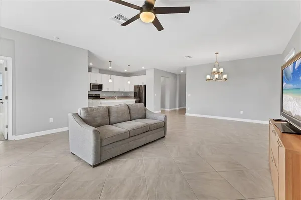 a kitchen with stainless steel appliances granite countertop a sink dishwasher a stove and a microwave oven with white cabinets