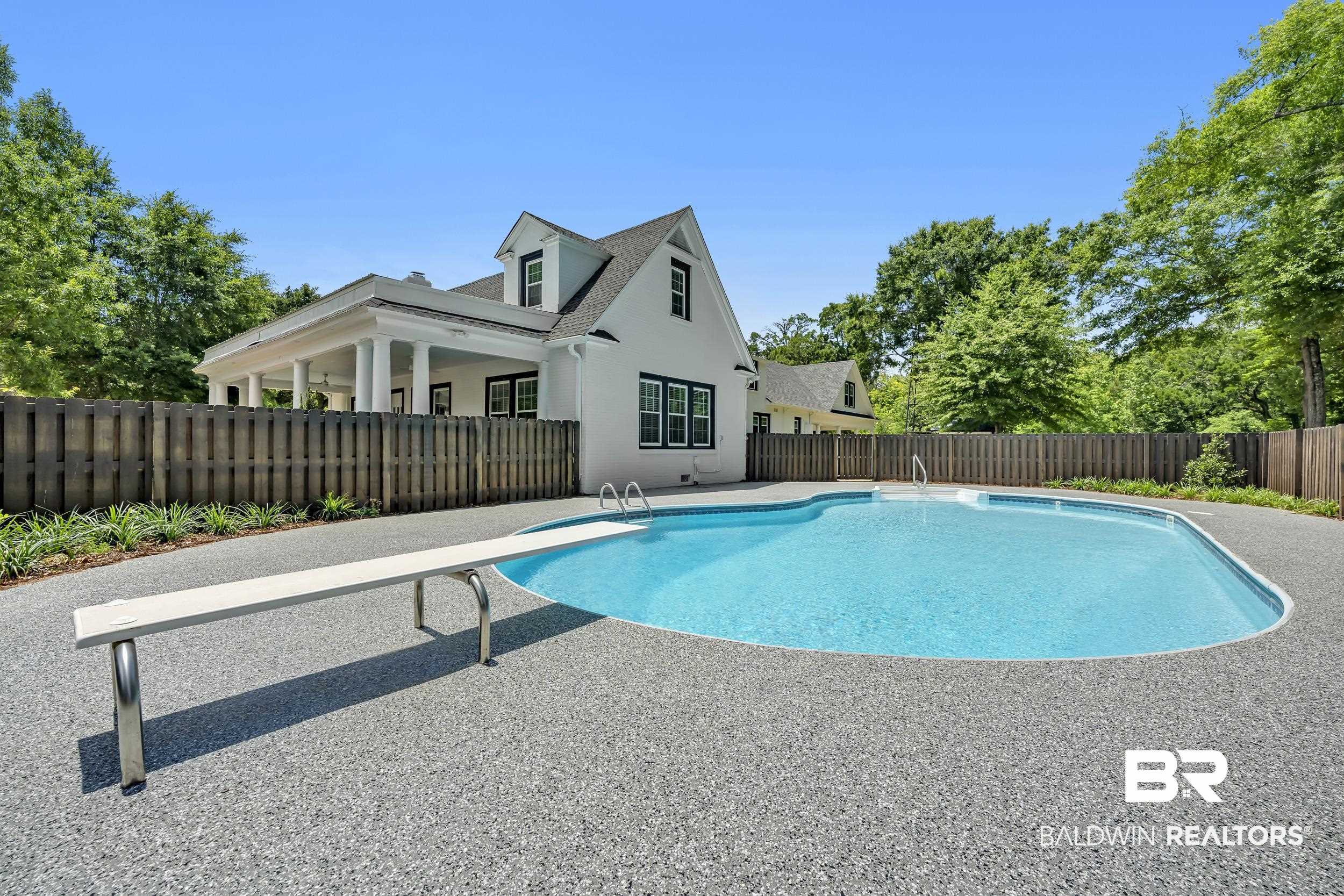 43199 Pine Grove Road Bay Minette, AL 36507 - Photo 2 of 71 Curved swimming pool with an exposed aggregate deck and diving board