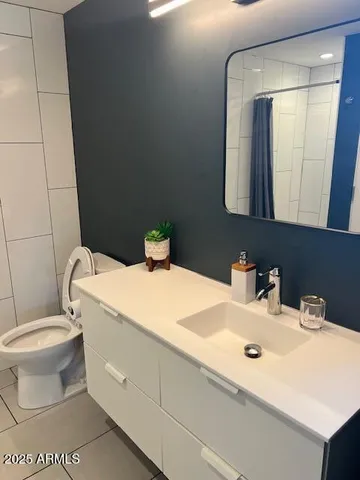 a bathroom with a sink toilet and mirror