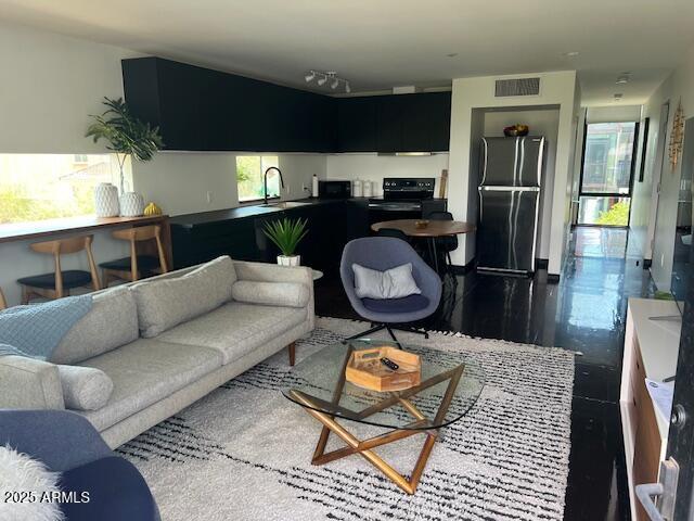 1436 South Terrace Road, Unit 102 Tempe, AZ 85281 - Photo 18 of 25 a living room with furniture a flat screen tv and kitchen view