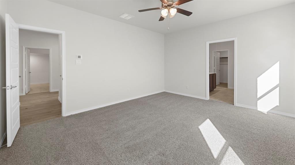 412 Carthage Street Caddo Mills, TX 75135 - Photo 9 of 32 Spacious room featuring neutral carpeting, white walls, and a ceiling fan with integrated lighting