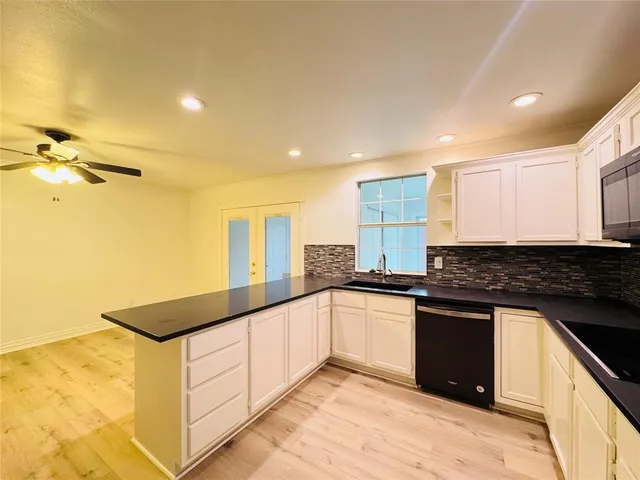 a kitchen with stainless steel appliances granite countertop a refrigerator a sink and a stove
