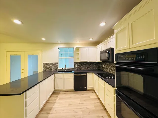 a view of a kitchen with stainless steel appliances a sink and cabinets
