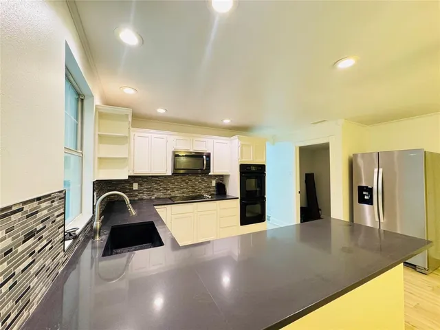 a kitchen with granite countertop a sink and cabinets