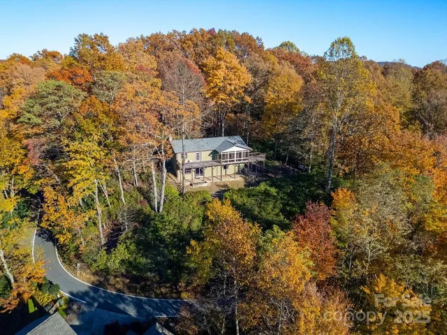 a spacious bedroom with a bed a chandelier and a window