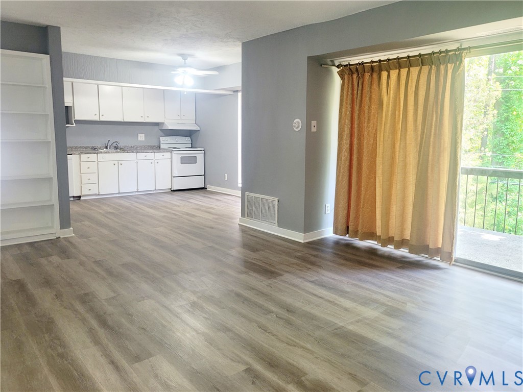 5204 Castlewood Road, Unit C Richmond, VA 23234 - Photo 1 of 12 a view of a kitchen with wooden floor and electronic appliances