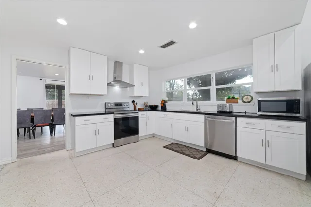 a kitchen with granite countertop white cabinets a counter and a sink