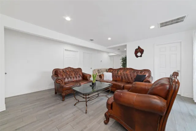 a living room with furniture and a wooden floor