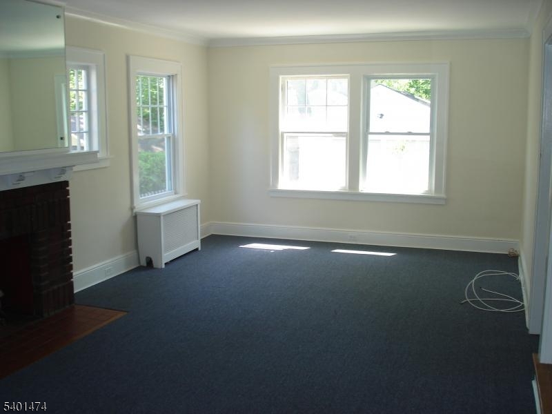 220 South Ridgewood Road South Orange, NJ 07079 - Photo 2 of 14 an empty room with a fireplace and windows