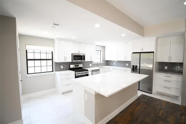 a view of kitchen with sink microwave refrigerator and cabinets