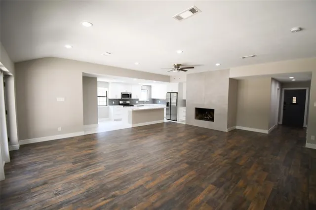 an empty room with wooden floor and fireplace