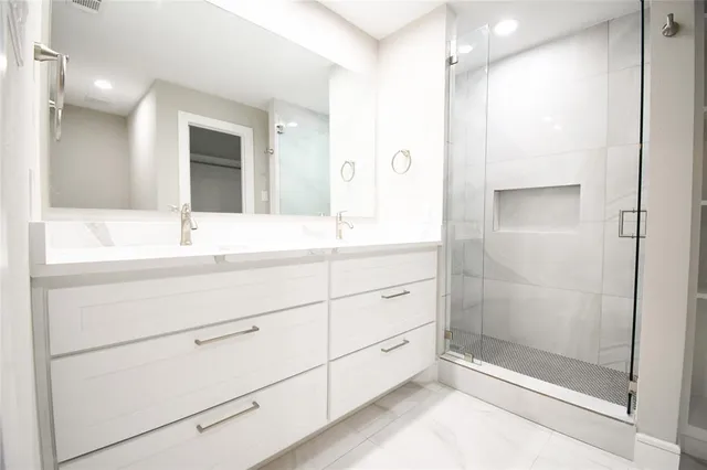 a bathroom with a shower sink and mirror