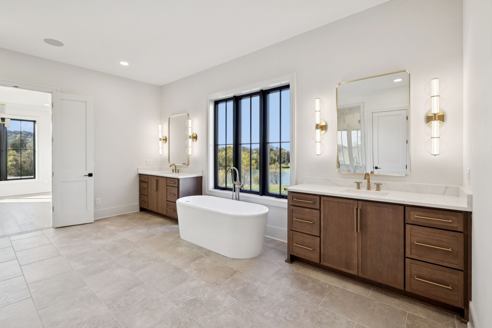 9204 Horton Highway College Grove, TN 37046 - Photo 36 of 87 a large bathroom with a double vanity sink a large mirror and a bathtub