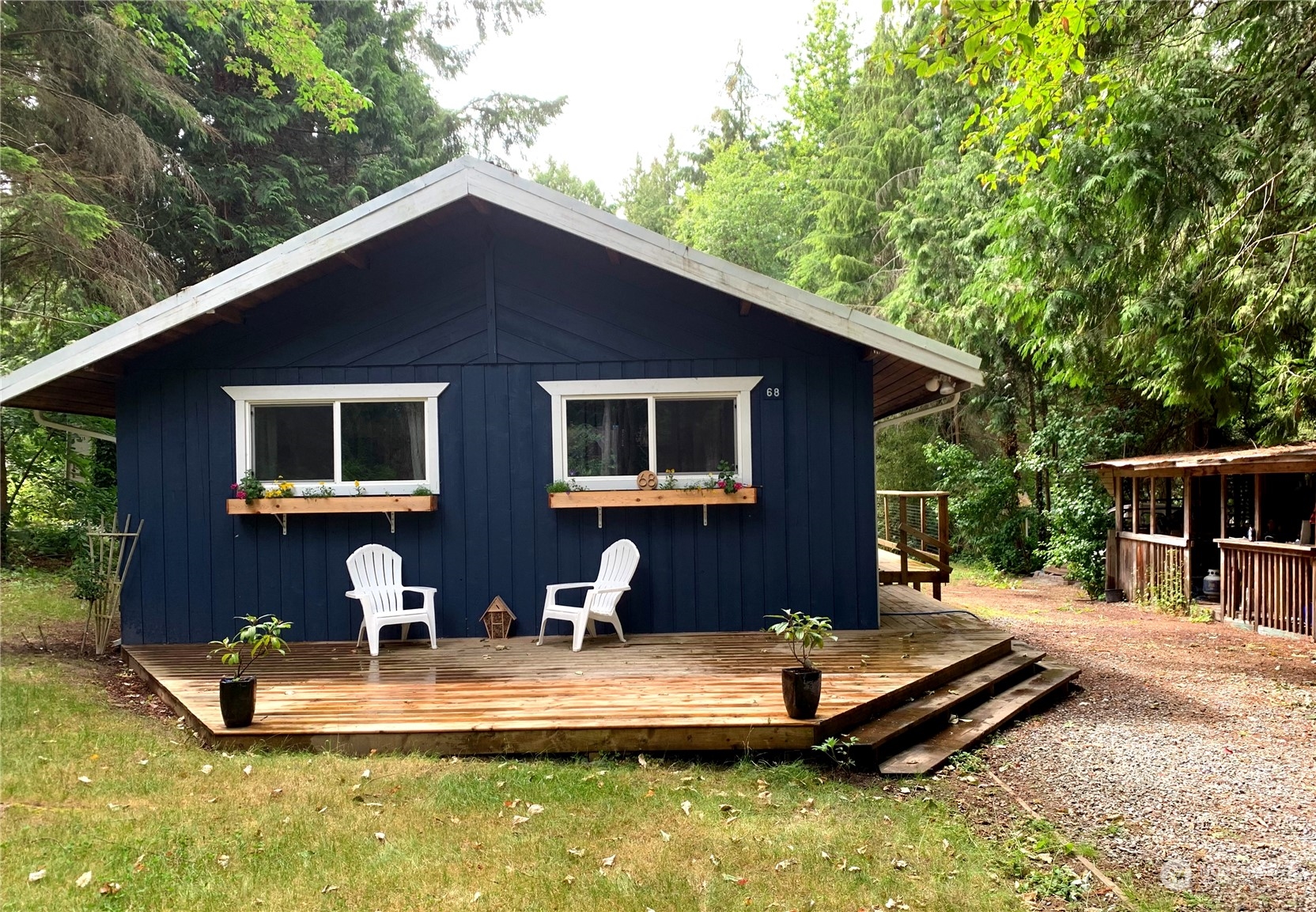 a front view of house with yard and trees in the background