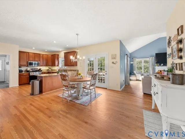 a kitchen with stainless steel appliances wooden floors and large windows