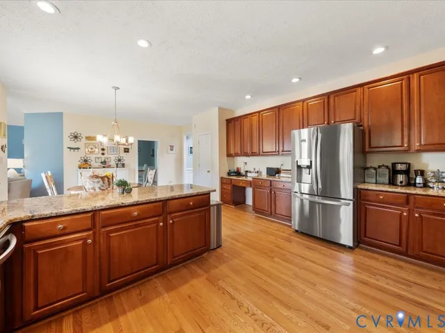 a kitchen with stainless steel appliances granite countertop a refrigerator a stove top oven a sink and dishwasher