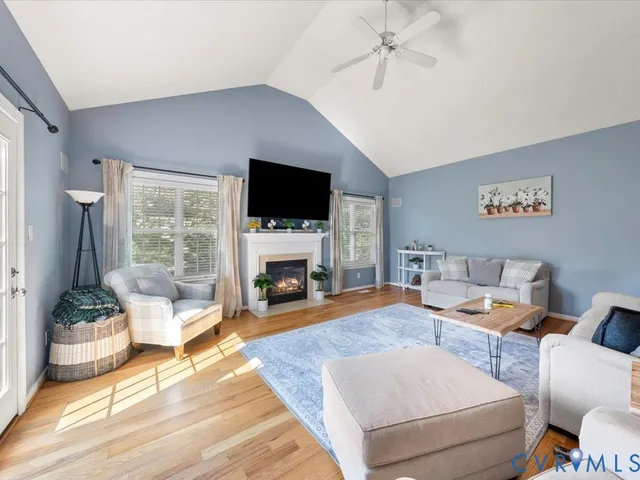a living room with furniture a fireplace and a flat screen tv