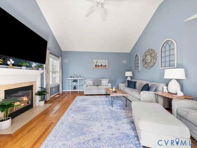 a living room with furniture a flat screen tv and a fireplace