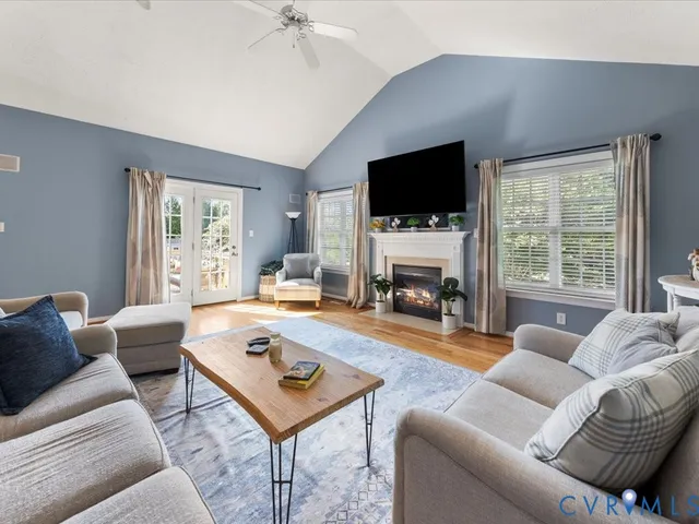 a living room with furniture a flat screen tv and a fireplace