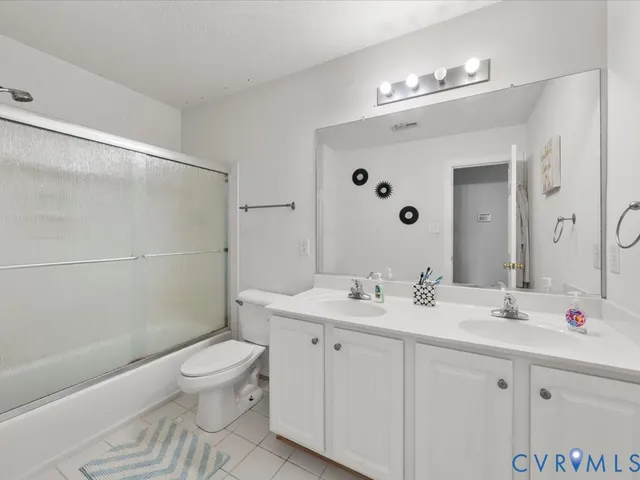 a bedroom with a bed and a potted plant on dresser