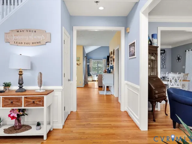 a view of a hallway with dining room and wooden floor