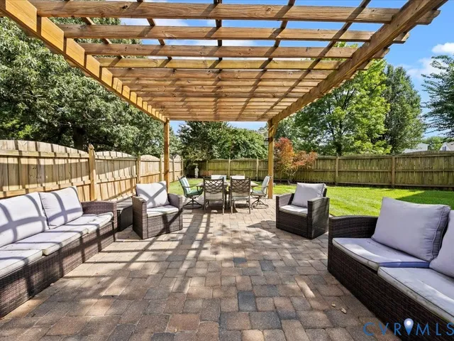 a view of a patio with a dining table and chairs with a wooden fence