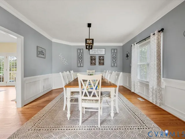 a dining room with furniture window and wooden floor