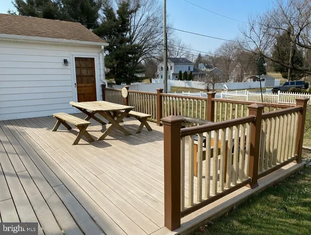 a view of a roof deck with wooden floor and fence