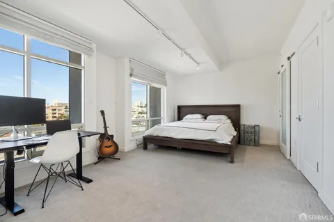 a spacious bedroom with a bed and a computer on the desk