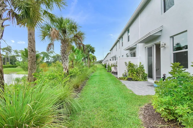 a front view of yellow house with a yard